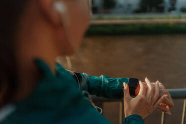 Sportliche Frau, die nach dem Training ihre Leistung auf der Smartwatch überprüft. Frau, die eine Smartwatch benutzt, um eine Textnachricht zu senden und anzurufen. Mockup für eine Uhr mit schwarzem Bildschirm. - HPIF35110