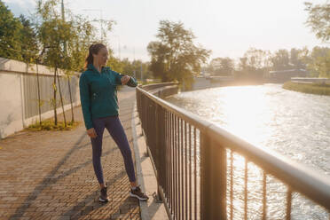 Junge Läuferin, die nach dem Training ihre Leistung auf dem Smartphone überprüft. Sportliches Mädchen, das sich auf eine morgendliche Joggingrunde vorbereitet. Outdoor-Workout-Konzept. - HPIF35111