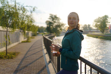 Porträt einer sportlichen Frau, die nach dem Training Wasser aus einer Flasche trinkt. Wichtig ist die Flüssigkeitszufuhr während des Trainings. - HPIF35122