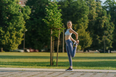 Full lenght Porträt der schönen Fitness-Frau Stretching vor Outdoor-Workout im Stadtpark. gesunden Lebensstil Konzept. kopieren Raum. - HPIF35144