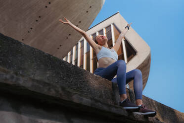 Happy fitness woman in sportswear enjoying feeling after workout session in the city. Beautiful sporty woman feeling good about yourself. - HPIF35206