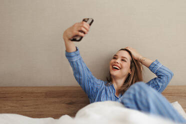 Young happy woman taking selfie in a bed. - HPIF35233