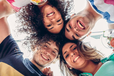 Close up of young happy people with their heads together having fun in a summer party. Young people lifestyle concept. View from below. - ADSF50276