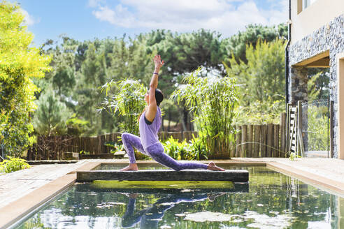 A woman practicing the yoga pose Crescent Lunge on the Knee (Anjaneyasana) - ADSF50330