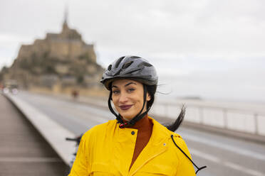 Smiling woman with cycling helmet on street  - JCCMF10986