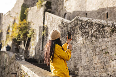 Woman taking selfie over smart phone on steps of Saint Michel castle - JCCMF10987