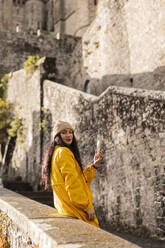 Traveler with smart phone standing at Saint Michel castle - JCCMF10988