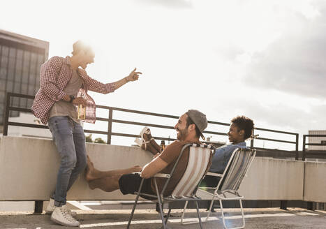 Carefree friends enjoying on rooftop under sky - UUF30744