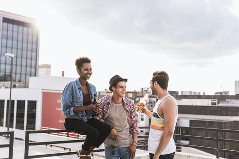 Happy friends having party on rooftop under sky - UUF30761