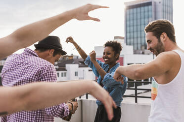 Happy friends dancing on rooftop - UUF30762