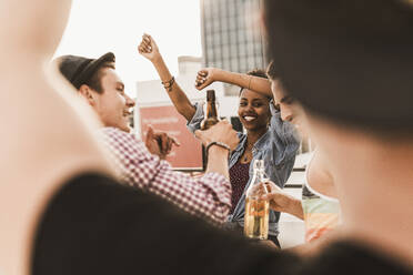 Happy friends enjoying party and dancing on terrace - UUF30764