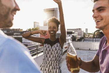 Carefree friends having party on rooftop - UUF30776
