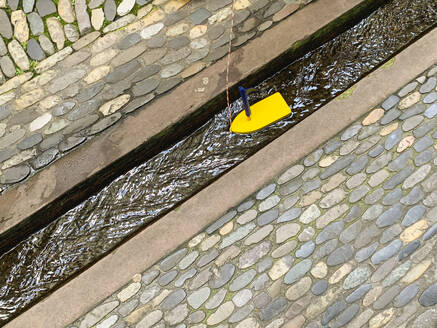 Deutschland, Baden-Württemberg, Freiburg im Breisgau, Kleines Holzboot im Freiburger Bachle runnel - GWF07957