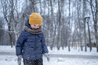 Smiling boy walking in winter park - ANAF02541