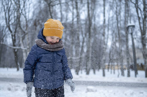 Smiling boy walking in winter park - ANAF02541