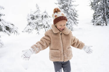 Happy girl playing with snow in winter forest - SVKF01781