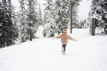 Girl running near trees in winter forest - SVKF01786