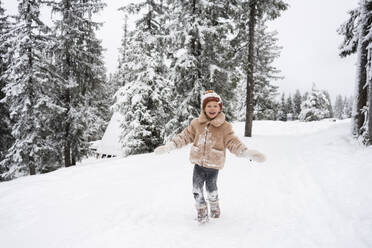 Smiling girl enjoying in winter forest - SVKF01787