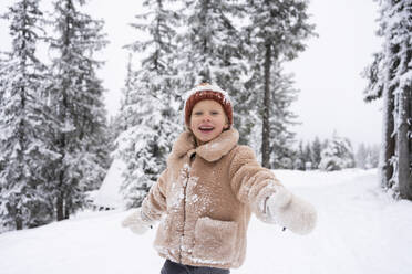 Happy girl with arms outstretched enjoying in winter forest - SVKF01788