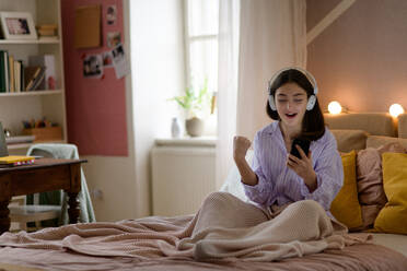 Teenager-Mädchen liegt im Bett und hört Musik. - HPIF35288