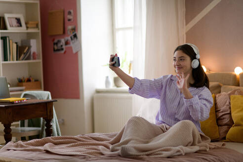 Junges Mädchen mit Videoanruf im Zimmer. - HPIF35289