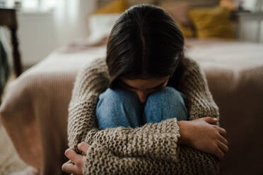 Teenage girl sitting on the floor with head on knees, koncept of mental health. - HPIF35293