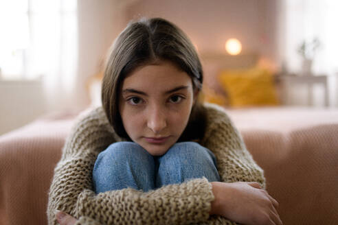 Teenager-Mädchen sitzt auf dem Boden mit dem Kopf auf den Knien, Konzept der psychischen Gesundheit. - HPIF35294