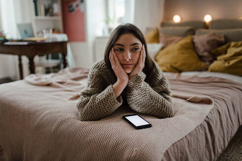 Junges Mädchen im Teenageralter mit Smartphone in einem Zimmer. - HPIF35304