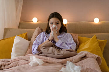 Sick teenage girl laying in the bed. - HPIF35330