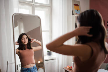 Portrait of smiling young woman standing wearing bra and pyjama