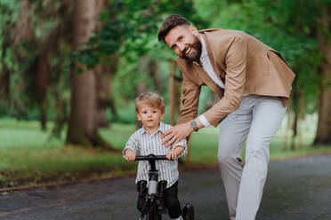 Ein alleinerziehender Vater verbringt mit seinem kleinen Sohn gemeinsame Zeit in einem öffentlichen Park. - HPIF35378