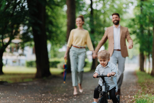 Junge Familie mit kleinem Sohn bei einem Spaziergang nach der Arbeit. - HPIF35379