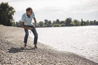 Senior man looking at sea in front of sky - UUF30851