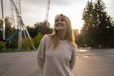 Happy beautiful woman in amusement park at sunset - VPIF08984