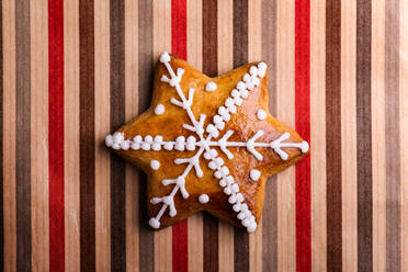Studio shot of gingerbread star on striped wrapping paper - HPIF35705