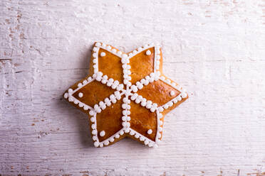 Gingerbread star. Studio shot on white wooden background. - HPIF35715