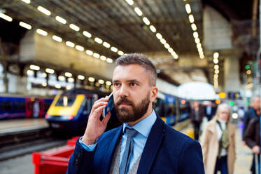 Junger gut aussehender Geschäftsmann mit Smartphone in der U-Bahn - HPIF35771