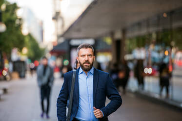 Hipster manager in blue shirt and jacket walking in the street of London - HPIF35812