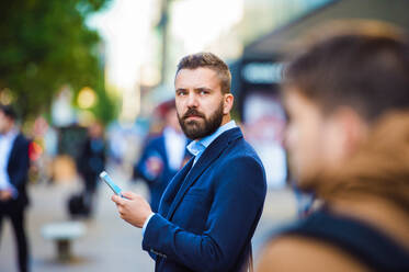 Hübscher junger Manager mit Smartphone in London - HPIF35828