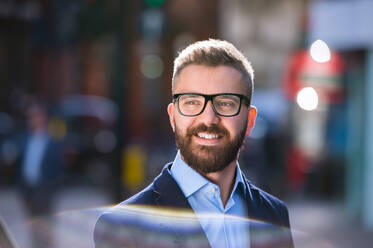 Hipster-Manager in blauem Hemd und Jacke auf der Straße in London, mit schwarzer Brille - HPIF35833