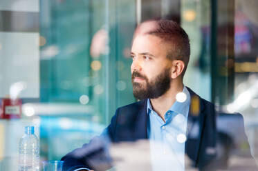 Double exposure of a handsome young man sitting in cafe - HPIF35840