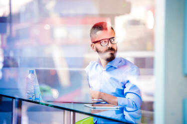 Hipster-Manager sitzt im Café am Fenster und arbeitet am Laptop, Straßenreflexion - HPIF35851