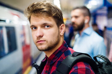 Junger gut aussehender Mann auf einem U-Bahn-Bahnsteig - HPIF35871