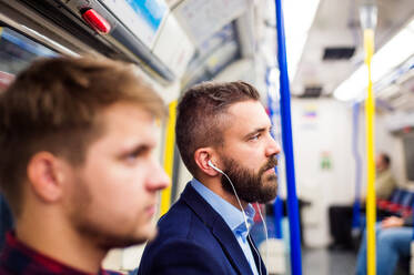 Zwei junge, gut aussehende Männer fahren mit der U-Bahn - HPIF35876