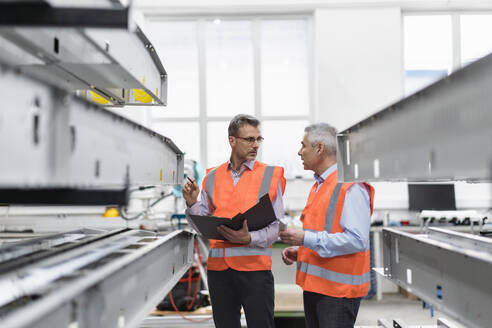 Engineers discussing over machinery in factory - DIGF21026