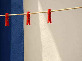 Clothespins hanging on empty clothesline - DSGF02490