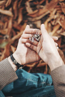 Man holding heart shaped necklace in hand - SVCF00436