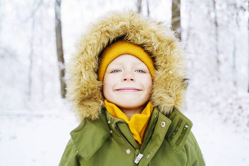 Smiling boy wearing parka coat in winter - NJAF00709