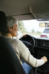 Smiling woman with gray hair driving car - EBSF04290