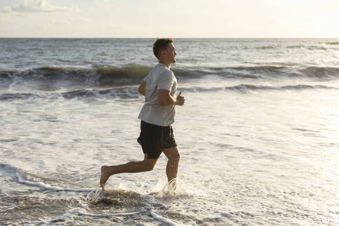 Man running in sea water at beach - STF00015